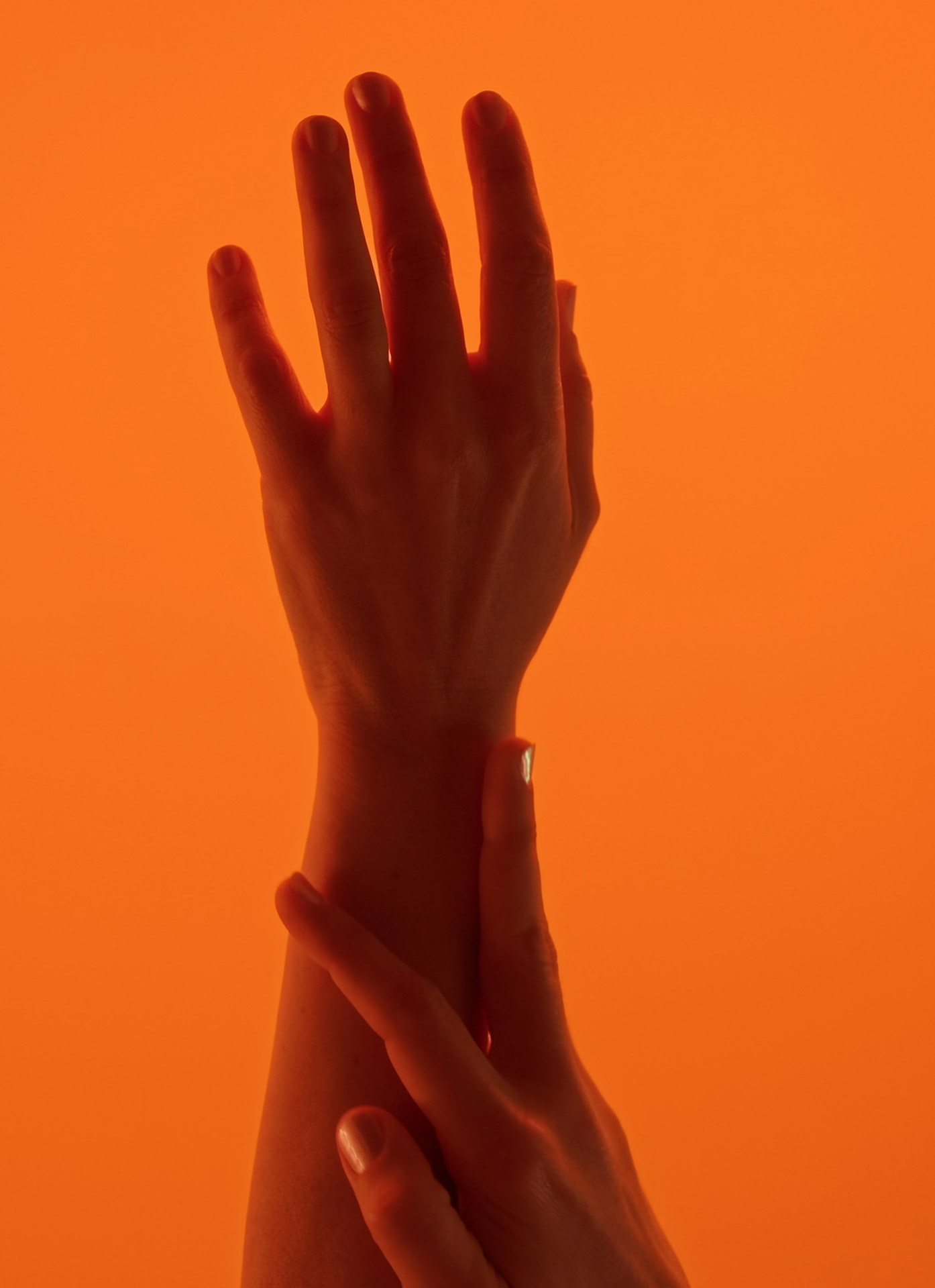 One hand resting against the opposite wrist, a study in touch and attention