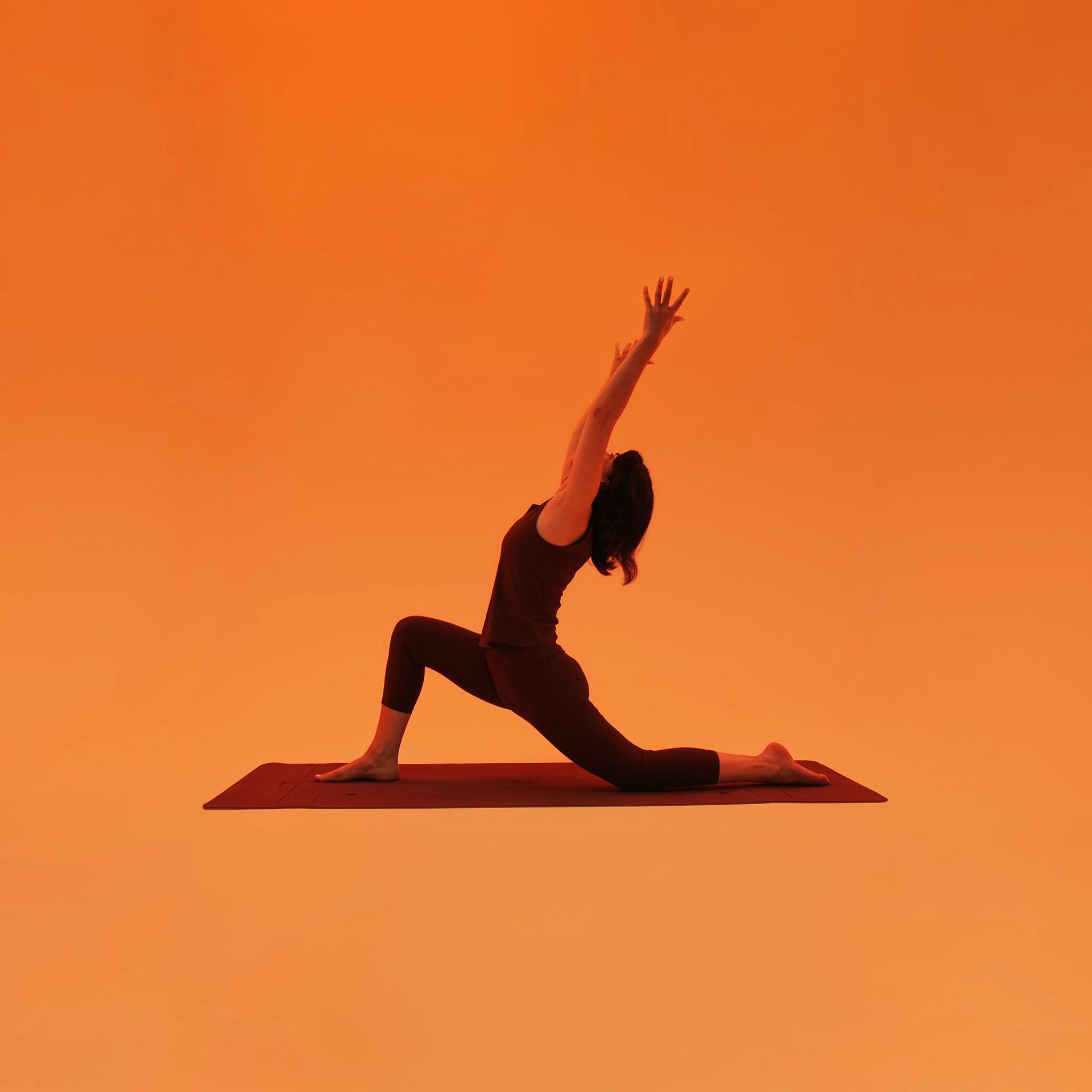 Yoga low lunge with arms lifted, practised on a mat
